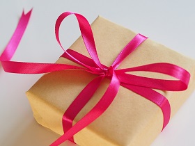 small box wrapped with brown paper tied with pink ribbon