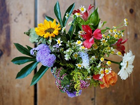 mixed colored flowers and leaves on wooden table